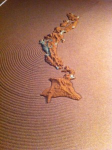 Map of Japan surrounded by sand. Raked concentric circles radiate from Fukushima